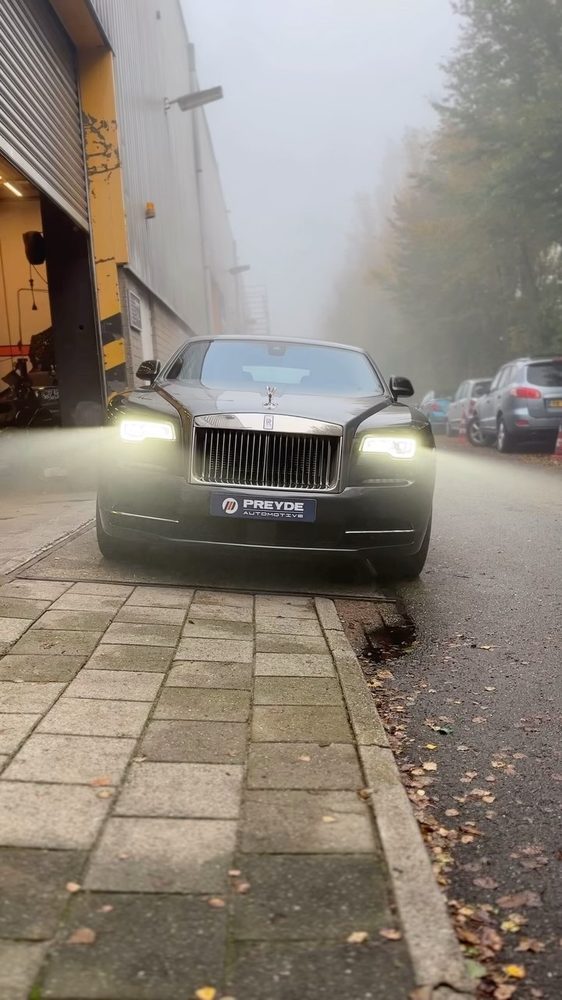 Rolls-Royce met verlichting aan op een mistige ochtend